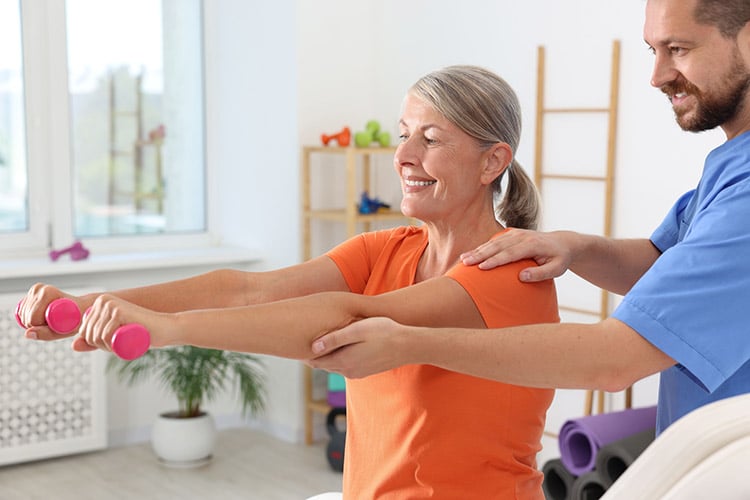 Senior woman doing strength training with a physical therapist