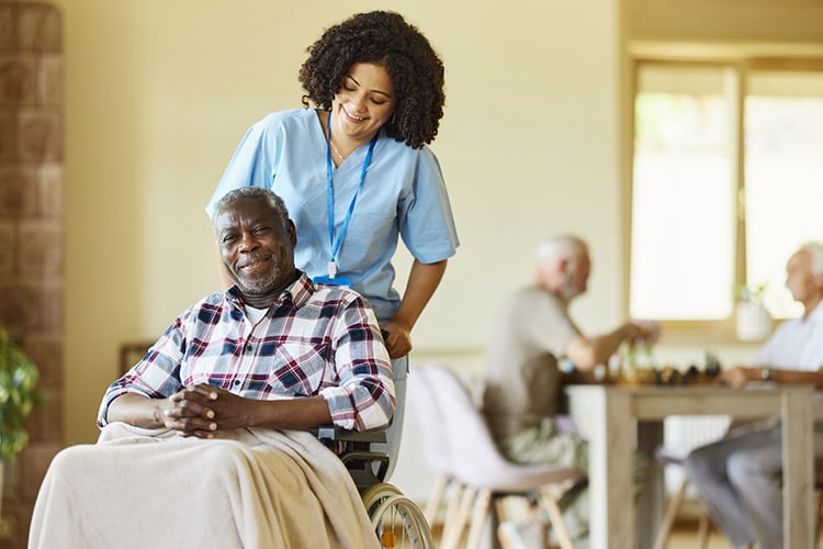 Respite care nurse assisting a senior man in a wheelchair