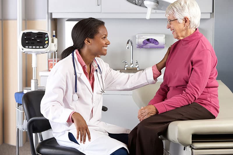 Physician talking with a patient in a skilled nursing examination room