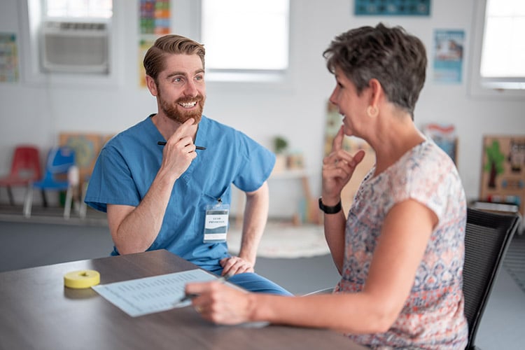 Speech language pathologist doing speech exercises with a senior woman